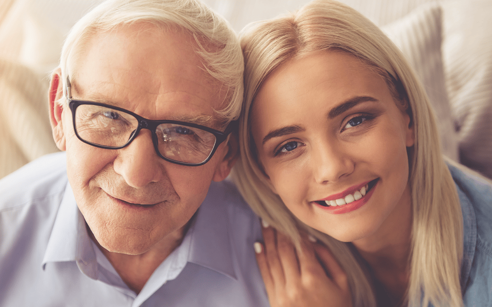 A young woman and her grandpa smile at the camera to signify they are happy they had a talk about the importance of a budget and sound financial planning, thanks to his financial advice.