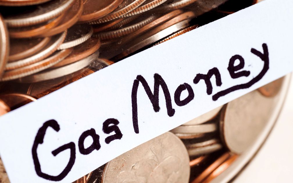 The image is a close-up of a glass jar of coins, labeled “Gas Money.”