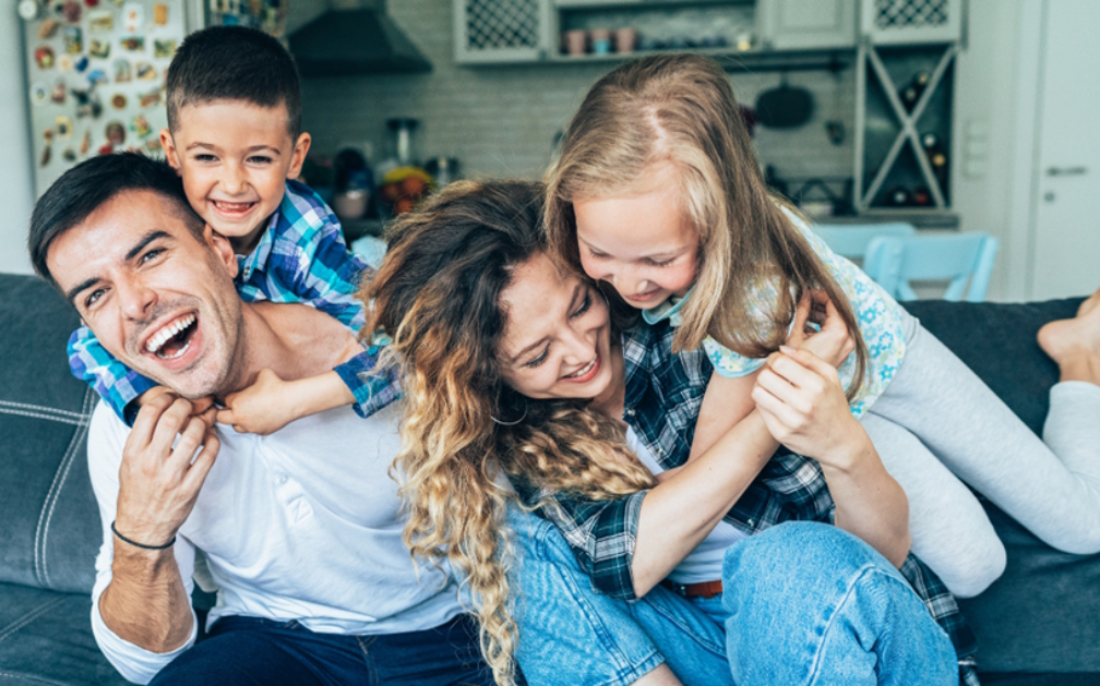 An image of a family of four hugging. PolicyWand makes it easy to find the best term life insurance for your family's needs.