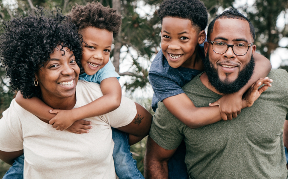 A family of 4 with 2 young children. Help protect your family's future with Term Life Insurance from PolicyWand.